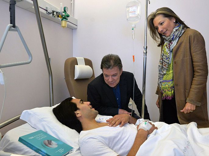 Handout picture released by Colombia's presidential press service showing Colombian President Juan Manuel Santos (C) and his wife Maria Clemencia Rodriguez visiting Monaco's Colombian football striker Radamel Falcao Garcia after his knee surgery at Hospital da Trindade in Oporto, Portugal, on January 25, 2014. Falcao Garcia's surgery was satisfactory, according to a brief statement released by the Colombian Football Federation. The star forward had suffered "an anterior cruciate ligament strain" following a challenge by Chasselay's Soner Ertek during a match of the French Cup last Wednesday. AFP