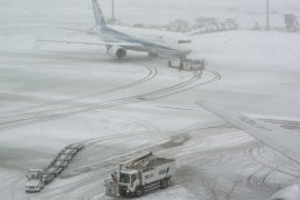 A jetliner of Japan's All Nippon Airways (ANA) taxis at Tokyo's Haneda airport covered by the snow on February 8, 2014. Heavy snow struck Tokyo and other areas across Japan, grounding nearly 300 flights and suspending some train services as the weather agency issued a severe storm warning for the capital. AFP PHOTO / KAZUHIRO NOGI