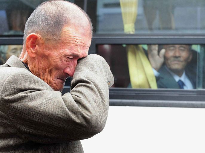 MOUNT KUMGANG, -, DEMOCRATIC PEOPLE'S REPUBLIC OF KOREA : (FILES) This file photo taken on October 31, 2010 shows an elderly South Korean man wiping his tears as a North Korean relative (in the bus) waves to say good-bye after a luncheon during a separated family reunion meeting at the Mount Kumgang resort on the North's southeastern coast, near the border. North Korea agreed on February 3, 2014 to hold talks with South Korea on organising a rare reunion event for families separated by the 1950-53 Korean War, Seoul's Unification Ministry said. REPUBLIC OF KOREA OUT AFP PHOTO / FILES / KOREA POOL