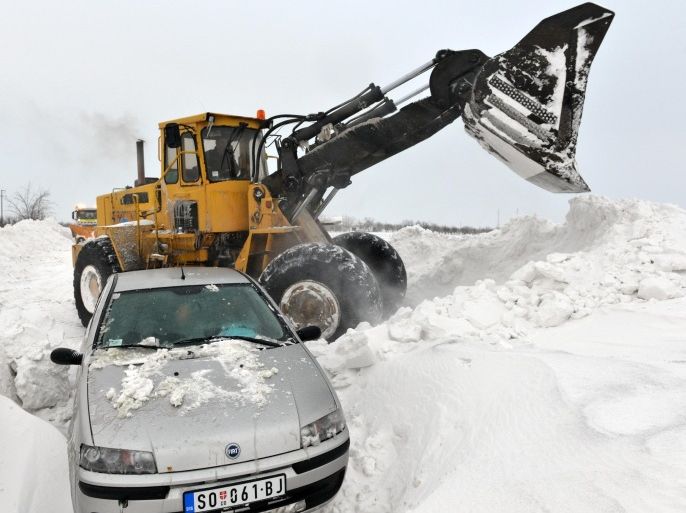 A road sweeping vehicle clears snow from the road near the city of Backa Topola, northern Serbia, Saturday, Feb. 1, 2014. Snow drifts formed by stormy winds have blocked two passenger trains and dozens of vehicles in northern Serbia, while authorities closed down several roads and a border crossing with Hungary. The state railway company says two trains to and from Hungary got stuck early on Saturday because of meters-high snow piles that formed on the railway. Emergency officials say several dozen passengers from the trains will be evacuated.(AP Photo/Darko Dozet) SERBIA OUT
