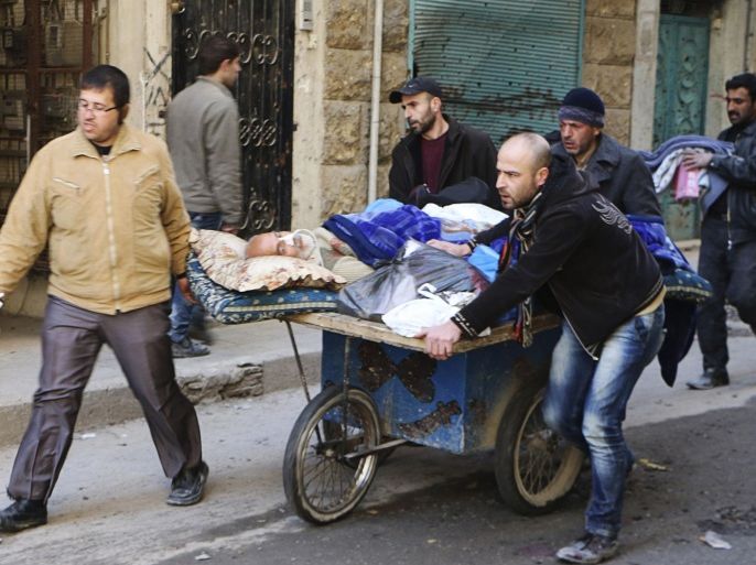 People wheel a sick man on a makeshift stretcher at the Karaj al-Hajez crossing, a passageway separating Aleppo's Bustan al-Qasr, which is under the rebels' control and Al-Masharqa neighbourhood, an area controlled by the regime February 9, 2014. REUTERS/Hosam Katan (SYRIA - Tags: POLITICS CIVIL UNREST CONFLICT)