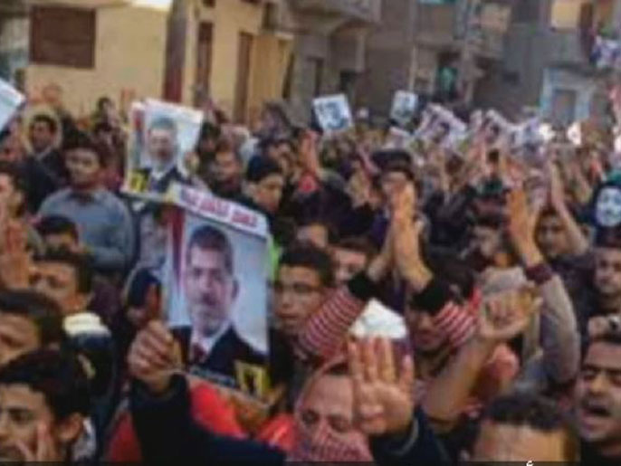 المتظاهرون رفعوا صور الرئيس المعزول محمد مرسي ولوحوا بإشارات رابعة (الجزيرة)