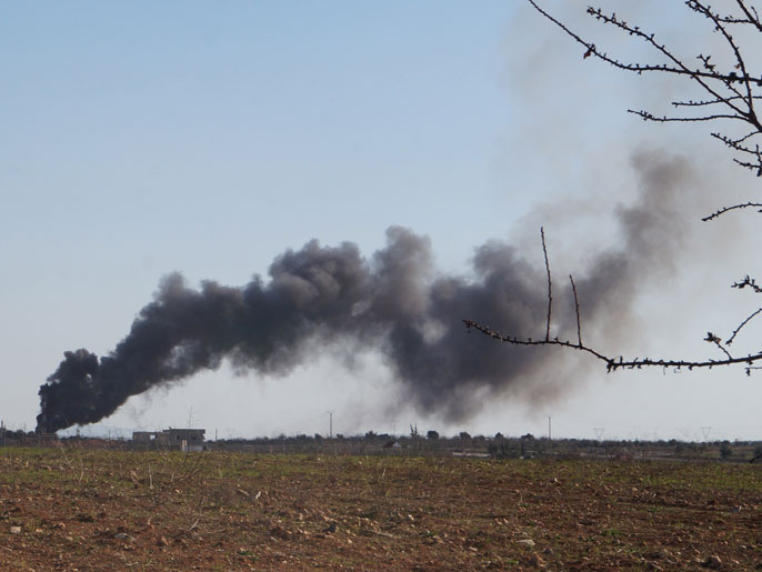 ‪سحابة دخان إثر استهداف موقع للقوات النظامية يضم ذخيرة بريف حماة‬  (الفرنسية)