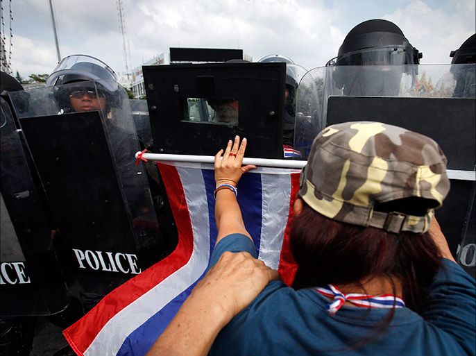 An anti-government protester pushes against a line of Thai police near Government House in Bangkok February 14, 2014