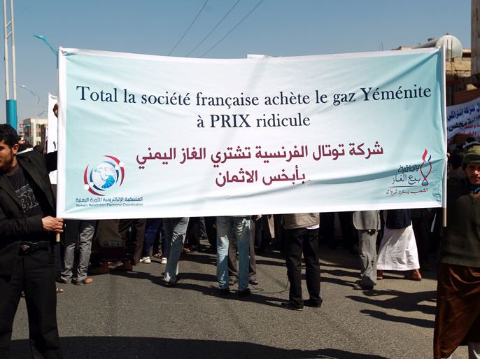 SAN06 - Sanaa, -, YEMEN : Yemeni protesters hold up banners against against France's oil group Total during a demonstration in the capital Sanaa on February 6, 2014 to demand an increase in Yemeni liquified natural gas prices for foreign companies that purchase gas from the Arabian peninsula's poorest nation. The few hundred protesters also demanded an end to a gas deal between Yemen and foreign firms led by French Total, which they insist is unfavourable.French and Arabic slogan reads: "Total is paying the a rediculous price for Yemeni gas." AFP PHOTO/ MOHAMMED HUWAIS