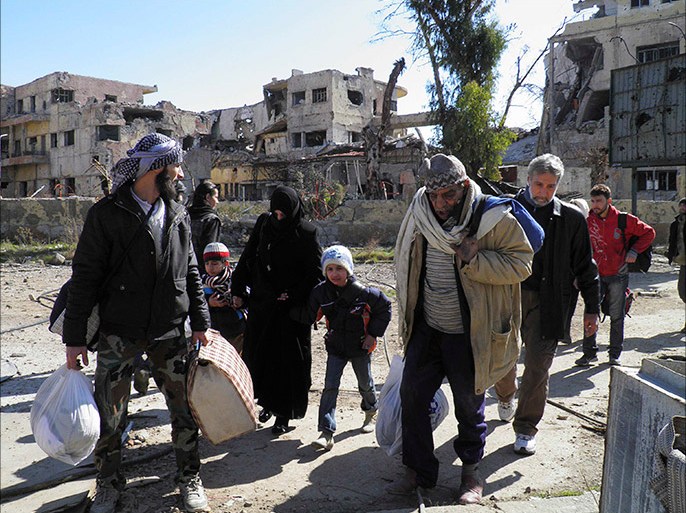 Civilians carry their belongings as they walk towards a meeting point to be evacuated from a besieged area of Homs February 7, 2014. Syria evacuated three busloads of civilians from a besieged area of Homs on Friday, the first stage of a planned three-day humanitarian ceasefire in the city which has suffered some of the worst devastation of Syria's three-year conflict. The buses carrying dozens of weary-looking evacuees, accompanied by Syrian Arab Red Crescent officials, arrived at a meeting point outside Homs watched by soldiers and police. REUTERS/Thaer Al Khalidiya (SYRIA - Tags: POLITICS CIVIL UNREST CONFLICT)