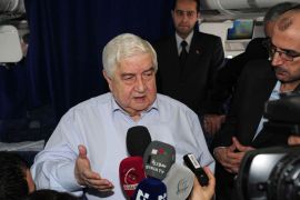 A handout picture released by the official Syrian Arab News Agency (SANA) on February 16, 2014, shows Syria's foreign minister Walid Muallem (C), head of the Syrian official delegation to the Geneva II conference, talking to journalists aboard a plane heading back to Syria. Muallem denied that a second round of peace talks with the opposition had failed, insisting that "important progress" was made in Geneva. AFP PHOTO / HO / SANA