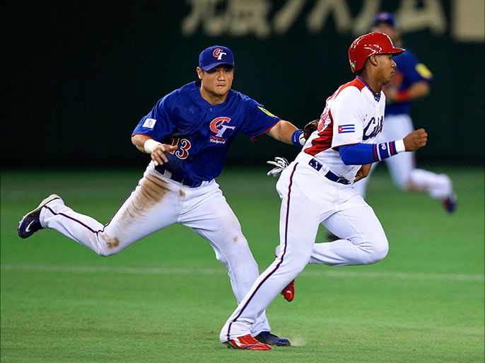 epa03616070 Cuba's infielder Erisbel Arruebarruena (R) is touched out by Taiwan's infielder Chen Yung-Chi (L) during the third inning of the World Baseball Classic second round game at Tokyo Dome in Tokyo, Japan, 09 March 2013