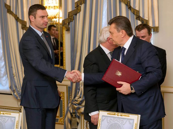 epa04093167 Ukrainian President Viktor Yanukovych(R) and opposition leader Vitali Klitschko (L) shake hands after signing the agreement in the Presidential Palace in Kiev, Ukraine, 21 February 2014