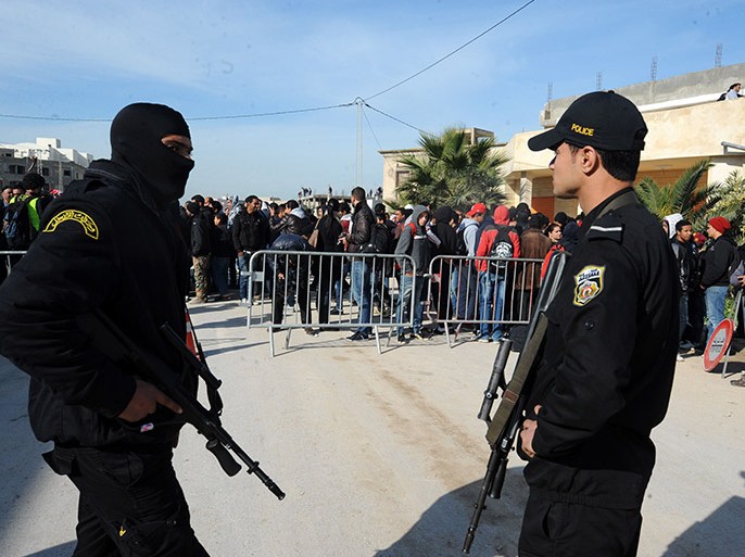 Tunis, -, TUNISIA : Special units of the Tunisian National Guard stand guard near a building (unseen) in the Tunis suburb of Raoued in which armed militants were holed up, on February 4, 201. A firefight between security forces and suspected Islamists hidden in the building has left one policeman and up to four militants dead. The standoff, which began Monday afternoon, was not yet over, a ministry spokesman told AFP, adding that so far a policeman and "between two and four terrorists" had been killed. AFP PHOTO / FETHI BELAID