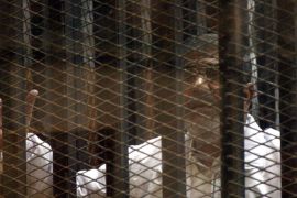 epa04045923 Ousted Egyptian President Mohammed Morsi talks from a cage in a makeshift courtroom inside a police academy in Cairo, Egypt, 28 January 2014.
