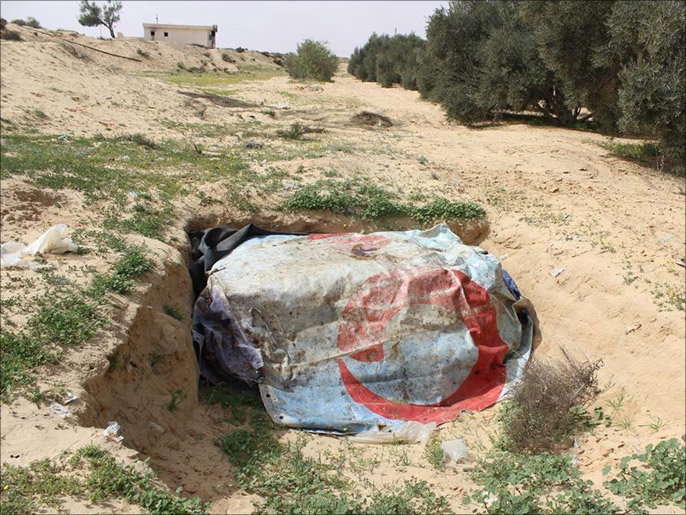 بعض الأهالي يدفنون ملابسهم في حفرةخشية احتراقها أثناء قصف المنزل (الجزيرة نت)