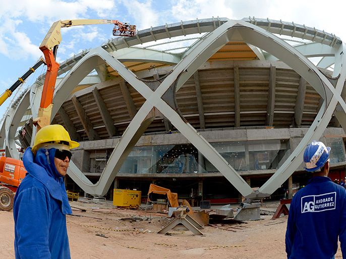 epa03990760 (FILE) A file picture dated 10 December 2013 shows workers at the construction site of the Arena Amazonia stadiumin Manaus, Brazil. According to media reports, a man died on 14 December 2013 after falling from the roof of the stadium. Manaus is one of the host cities of the FIFA World Cup 2014 and will stage four games in the group phase. EPA/MARCUS BRANDT