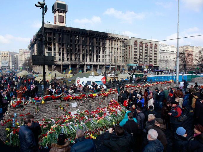 People lay flowers at the barricades in memory of the victims of the recent clashes in central Kiev February 24, 2014. Fugitive Ukrainian President Viktor Yanukovich, ousted after bloody street protests in which demonstrators were shot by police snipers, is wanted for mass murder, authorities announced on Monday. REUTERS/David Mdzinarishvili (UKRAINE - Tags: POLITICS CIVIL UNREST)