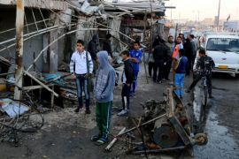 Civilians inspect the site of a car bomb attack in the eastern Ur neighborhood of Baghdad, Iraq, Tuesday, Feb. 18, 2014. A wave of explosions rocked mainly Shiite neighborhoods in Baghdad shortly after sunset on Monday, killing and wounding scores of people, said Iraqi officials. (AP Photo/Karim Kadim)