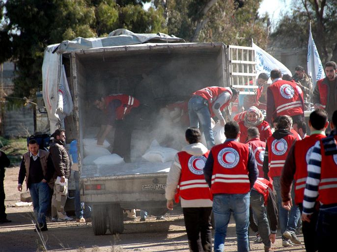 epa04072459 Syrian Red crescent members and workers of the United Nations distribute flour bags and food boxes to residents in the old city of Homs in Homs province, Syria, 12 February 2014