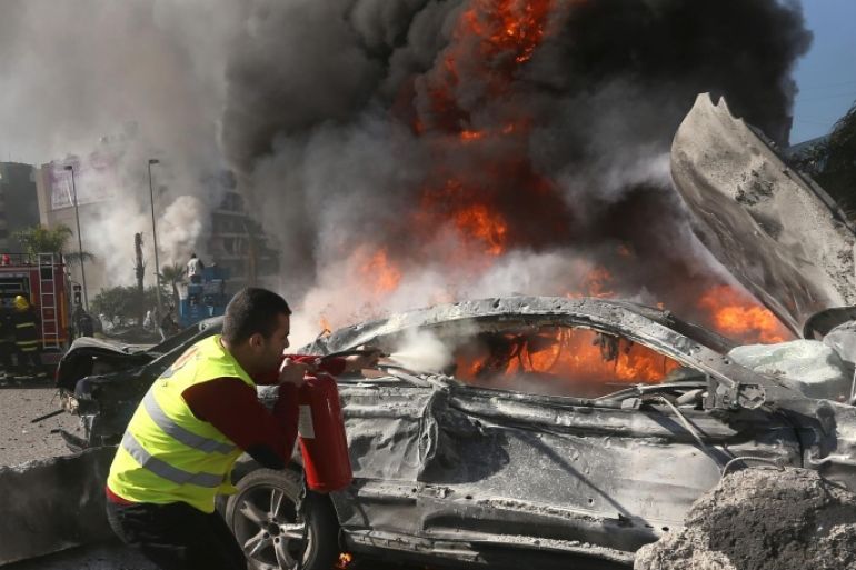 A Lebanese firefighter extinguishes a burned car at the site of an explosion, near the Kuwaiti Embassy and Iran's cultural center, in the suburb of Beir Hassan, Beirut, Lebanon, Wednesday, Feb. 19, 2014. A blast in a Shiite district in southern Beirut killed several people on Wednesday, security officials said — the latest apparent attack linked to the civil war in neighboring Syria that has killed and wounded scores of people over the last few months. (AP Photo/Hussein Malla)