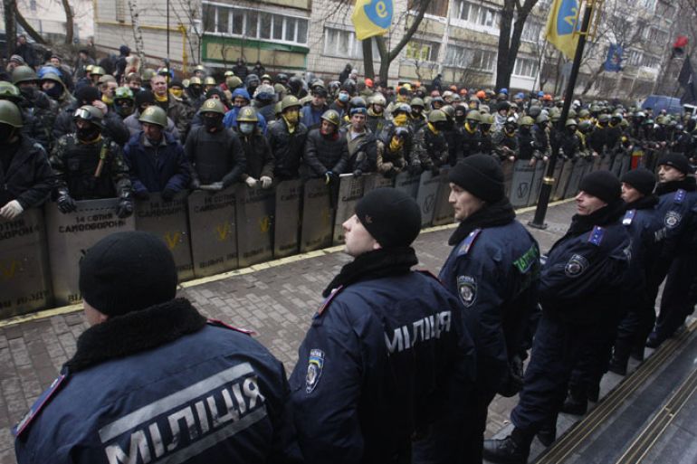 Kiev, -, UKRAINE : Anti-government protestors of the "14 Hundred Self-Defense" group face police as they take part in a protest rally in front of the Prosecutor General building in Kiev on February 14, 2014. Protesters armed with shields and clubs demanded the government stop prosecuting cases against anti-government activists involved in clashes with police. AFP PHOTO / YURY KIRNICHNY