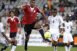 Ghana's midfielder Jordan Opoku (L) vies with Libya's forward Mohamed Elgadi (R) during the African Nations Championship final football match for 1st and 2nd place between Ghana and Libya, in Cape Town, on February 1, 2014. AFP PHOTO / ALEXANDER JOE