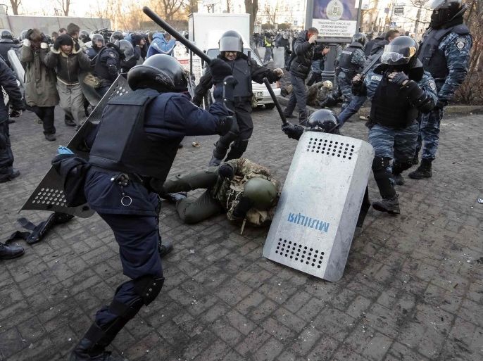 Riot police beat an anti-government protester during clashes in Kiev February 18, 2014. Ukrainian riot police charged protesters occupying a central Kiev square early on Wednesday after the bloodiest day since the former Soviet republic, caught in a geopolitical struggle between Russia and the West, won its independence. REUTERS/Stringer (UKRAINE - Tags: POLITICS CIVIL UNREST CRIME LAW)