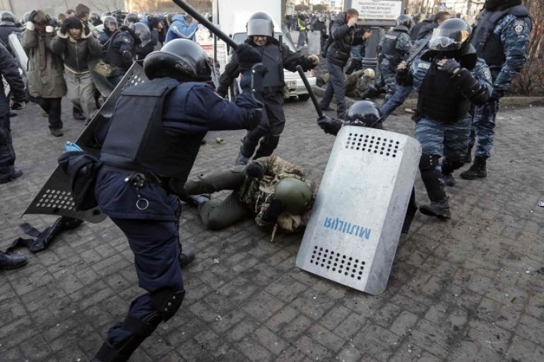 Riot police beat an anti-government protester during clashes in Kiev February 18, 2014. Ukrainian riot police charged protesters occupying a central Kiev square early on Wednesday after the bloodiest day since the former Soviet republic, caught in a geopolitical struggle between Russia and the West, won its independence. REUTERS/Stringer (UKRAINE - Tags: POLITICS CIVIL UNREST CRIME LAW)