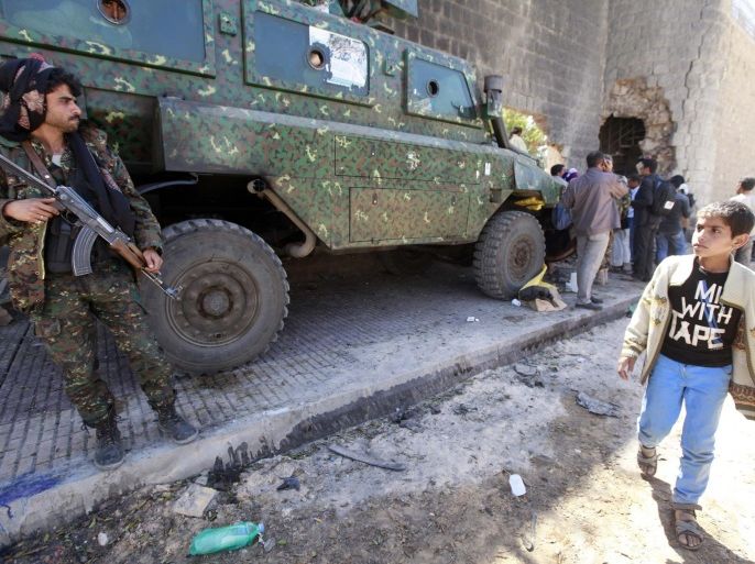A boy walks alongside an armoured vehicles outside the central prison in Sanaa after a bomb exploded outside its main wall, February 14, 2014. Eleven people were killed when attackers mounted a bomb, grenade and gun assault on the main prison in Yemen's capital on Thursday to try to free inmates, security sources and witnesses said. Explosions and gunfire could be heard several kilometres away from the prison in northern Sanaa, which has al Qaeda members among its inmates. The biggest explosion rattled windows in the area. REUTERS/Mohamed al-Sayaghi (YEMEN - Tags: CIVIL UNREST)