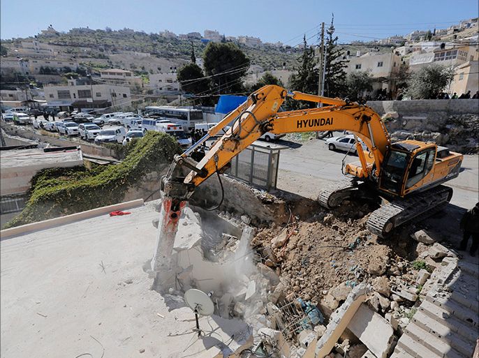 A bulldozer demolishes a house in Jabel Mukaber, a Palestinian village in the suburbs of East Jerusalem, in this February 5, 2014 file picture. Aid agencies working in the occupied West Bank and East Jerusalem expressed alarm on Friday at a spike in Israeli demolitions of Palestinian property coinciding with renewed U.S.-backed peace negotiations. REUTERS/Ammar Awad/Files (JERUSALEM - Tags: POLITICS CIVIL UNREST)