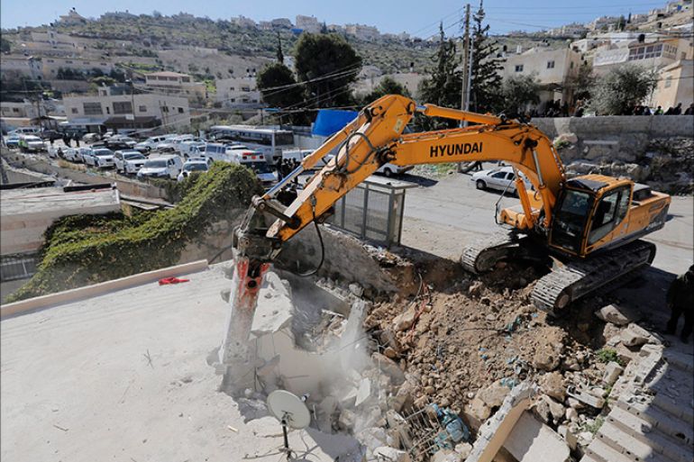 A bulldozer demolishes a house in Jabel Mukaber, a Palestinian village in the suburbs of East Jerusalem, in this February 5, 2014 file picture. Aid agencies working in the occupied West Bank and East Jerusalem expressed alarm on Friday at a spike in Israeli demolitions of Palestinian property coinciding with renewed U.S.-backed peace negotiations. REUTERS/Ammar Awad/Files (JERUSALEM - Tags: POLITICS CIVIL UNREST)