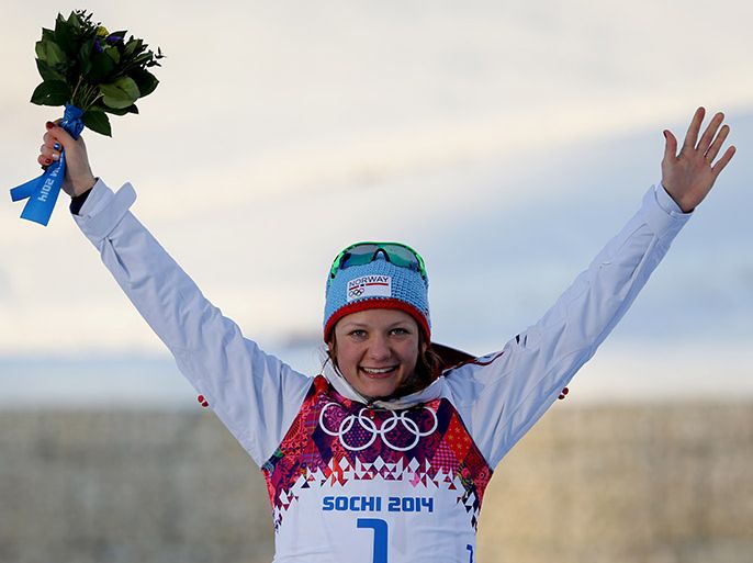 epa04069085 Maiken Caspersen Falla of Norway celebrates winning the gold medal during the flower ceremony of the Women's Sprint Free competition at the Laura Cross Country Center during the Sochi 2014 Olympic Games, Krasnaya Polyana, Russia, 11 February 2014. EPA