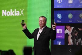 Nokia's Chief Executive Stephen Elop holds up the Nokia X at its unveiling at the Mobile World Congress in Barcelona, February 24, 2014. Nokia, soon to be acquired by Microsoft Corp, is turning to software created by arch-rival Google for a new line of phones it hopes will make it a late contender in the dynamic low-cost smartphone market. Its first model, the Nokia X, will rely upon an open version of the Android mobile software system created by Google that has become the world's most popular software used in smartphones. REUTERS/Gustau Nacarino (SPAIN - Tags: BUSINESS TELECOMS)