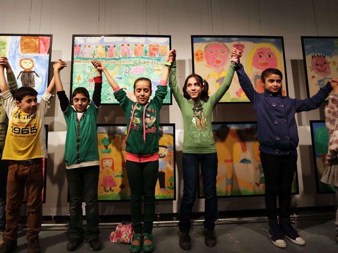 AA493 - Beirut, -, LEBANON : Syrian refugee children pose for a photo during the "Light Against Darkness" exhibition displaying art by Syrian refugee children in Beirut on February 21, 2014. The exhibition is the result of a three month workshop supervised by artists to provide psychological support for Syrian refugees. AFP PHOTO / ANWAR AMRO