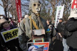 A man wearing a protective suit and mask takes part in a demonstration denouncing nuclear power plants during a march toward the prime minister's official residence and the National Diet in Tokyo on March 9, 2014