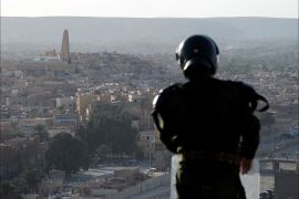 A member of the Algerian security forces stands guard on a ridge looking down on the Algerian city of Ghardaia on March 18, 2014 during an operation to secure the city following sectarian clashes. The city of 90,000 inhabitants has been rocked since December by clashes between the Chaamba community of Arab origin and the majority Mozabites, indigenous Berbers belonging to the Ibadi Muslim sect. AFP PHOTO / FAROUK BATICHE