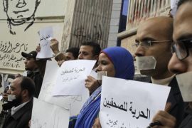 Egyptian journalists tape their mouths during a protest demanding press freedom in front of the Syndicate of Journalists building in Cairo, Egypt, Wednesday, March 5, 2014. Arabic reads "Freedom to journalists, we are not criminals." (AP Photo/Amr Nabil)