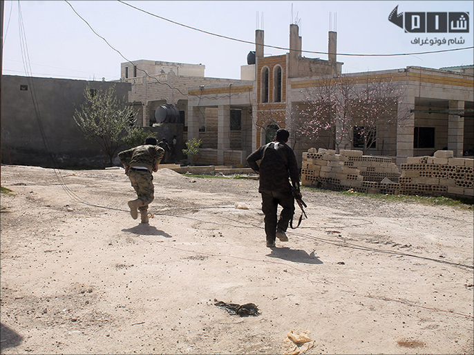 مقاتلون على جبهة بمدينة مورك بريف حماة الشمالي (الجزيرة)