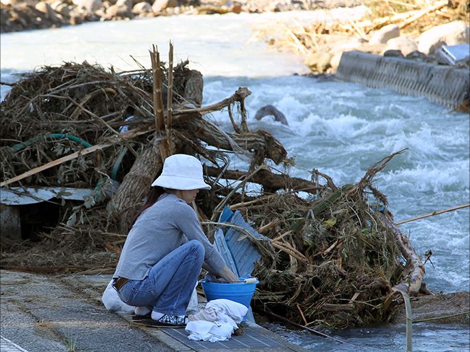 epa02901207 A local resident washes her clothes in the river due to the electric and water outage caused by the flooding of the Nachi River after a large typhoon and heavy rain hit western Japan, in Nachikatsuura Town, Wakayama Prefecture, Japan on 06 September 2011. The Nachikatsuura Town Mayor has announced that more than 500 houses are flooded in the town. Across the country, 33 people are found dead and 56 people are still missing. EPA/KOICHI KAMOSHIDA