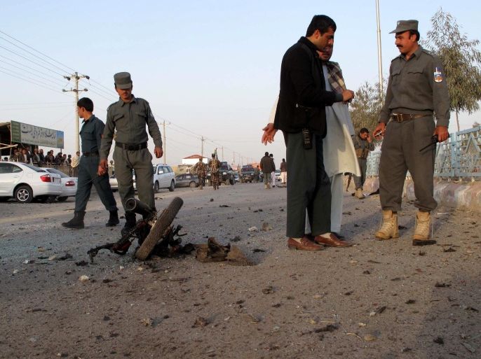 Afghan security officials inspect the site of a bomb blast in Lashkargah, Helmand province, Afghanistan, 24 Febraury 2014. According to media reports, five civilians were injured in the blast.