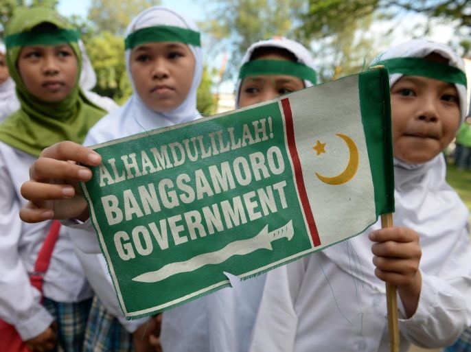 Young Muslims hold a Moro Islamic Liberation Front (MILF) miniature flag as they gather for a rally in support of the peace agreement with the government in Cotabato City, on the southern island of Mindanao on March 27, 2014. The Philippine government and Muslim rebels will sign a pact on March 27, to end one of Asia's longest and deadliest insurgencies, but both sides caution much work needs to be done to secure a lasting peace. AFP PHOTO/TED ALJIBE