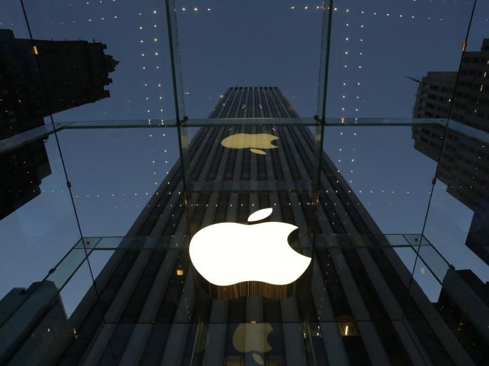 FILE - In this Wednesday, Nov. 20, 2013, file photo, the Apple logo is illuminated in the entrance to the Fifth Avenue Apple store, in New York. Apple Inc. reports quarterly financial results after the market closes Monday, Jan 27, 2014. (AP Photo/Mark Lennihan, File)