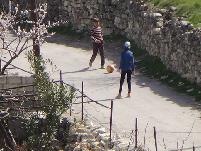 أطفال ريف اللاذقية يلعبون غير آبهين بالقصف المتواصل (الجزيرة)