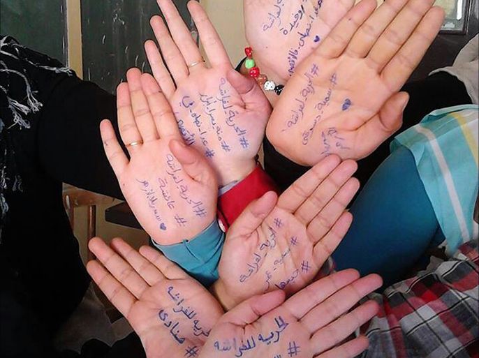 حرية فراشة ..حملة للتضامن مع المعتقلات - مجموعة من اعضاء الحملة يكتبون عبارات مطالبة بحرية معتقلات على ايديهم
