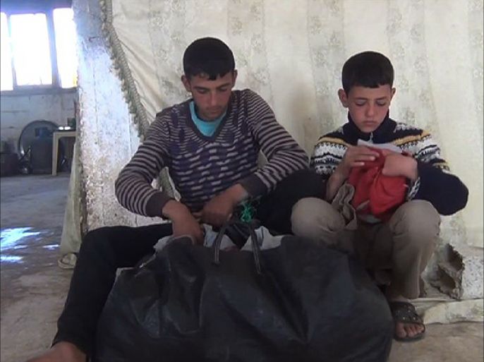 الطفلين أحمد وأسامة يحضران أغراضهما قبيل اللجوء للأردن