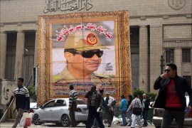People walk past a huge banner for Egypt's army chief, Field Marshal Abdel Fattah al-Sisi in front of the High Court of Justice in downtown Cairo, March 13, 2014. Cairo's souvenir shops and street stands are filled with memorabilia celebrating al-Sisi. Egypt is pushing ahead with an army-backed plan for political transition, with presidential and parliamentary elections due to take place within months. Sisi is widely expected to announce his presidential bid and win easily. Poster reads, "We love and support you. You are our president and leader". REUTERS/Amr Abdallah Dalsh (EGYPT - Tags: POLITICS MILITARY ELECTIONS)