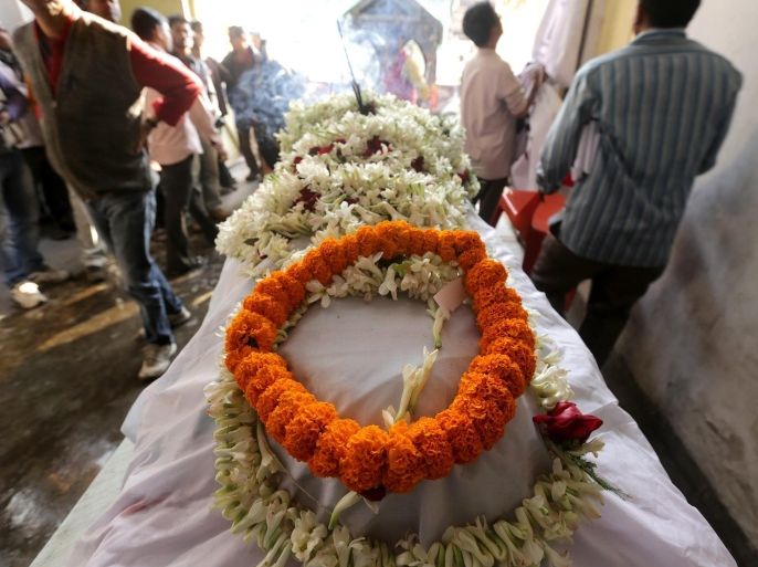 A rape victim's dead body is covered in floral tributes before a protest march in Calcutta, eastern India on 01 January 2014. A young girl was gang-raped on 25 October 2014 and afterwards repeatedly threatened by the accused, following which the disturbed girl set herself on fire December 23. She was admitted to the hospital with 40 percent burns and finally succumbed to her burn injuries on 31 December 2013. Opposition Communist party organise a protest march along with victims relatives and thousand activists as they shout against Bengal Government.