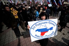A woman holds a placard bearing the map of Crimea coloured in the russian flag during a pro Russian rally in Simferopol's Lenin Square on March 9, 2014. Ukrainian Prime Minister Arseniy Yatsenyuk on Sunday vowed Ukraine would not give "an inch" of its territory to Russia, at a rally of thousands of people in Kiev in honour of 19th-century national hero Taras Shevchenko. AFP PHOTO/Filippo MONTEFORTE