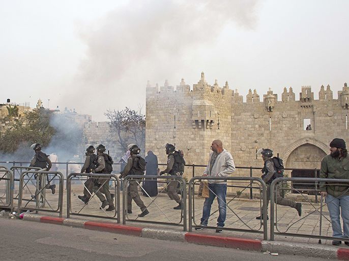 Israeli security forces clash with Palestinian protesters in front of Jerusalem's Damascus Gate leading into the Old City, on March 16, 2014, which is one of the gates that leads to the al-Aqsa Mosque compound, home to the Dome of the Rock, and Islam's third holy site. The clashes errupted after hundreds of young Palestinians who had gathered outside the walls of Jerusalem's Old City with books to encourage people to read more, heard that the far-right Israeli Housing Minister Uri Ariel, deputy leader of the hardline national religious Jewish Home party, made a short visit to the flashpoint Al-Aqsa mosque compound. AFP