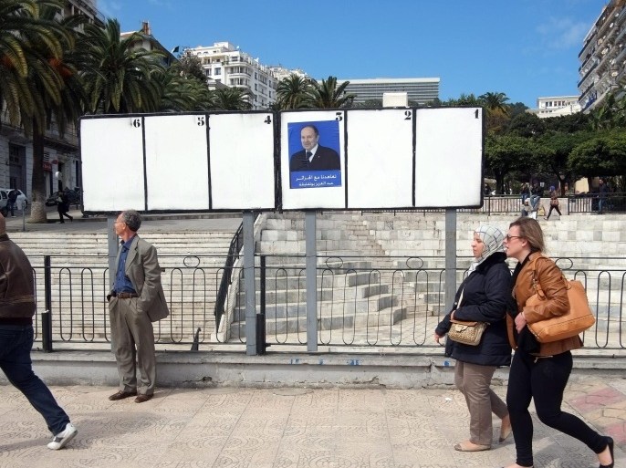 Algerian people walk near an electoral billboard with photo for Algerian President Abdelaziz Bouteflika in Algiers, Algeria, 23 March 2014. Campaigning for the upcoming presidential elections started on 23 March 2014. The Algerian Constitutional Council announced on 13 March 2014 a list of six candidates who will run in the presidential elections scheduled for 17 April. Several opposition parties and civil society groups have called for a boycott of the vote after President Abdelaziz Bouteflika announced he will run for a fourth five-year term.
