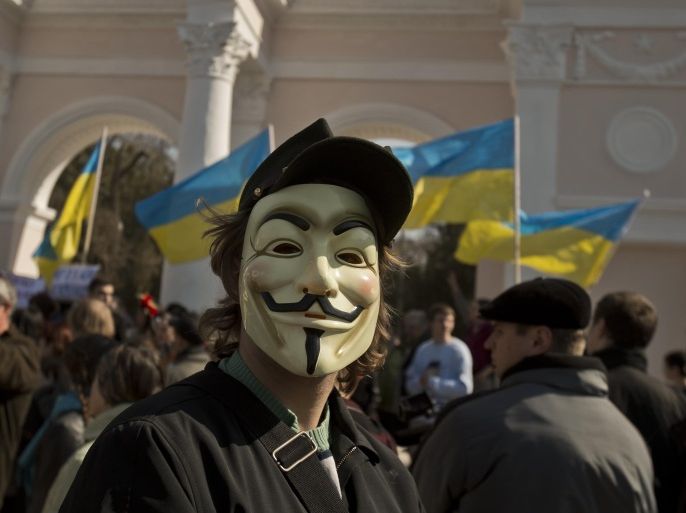 A pro-Ukrainian demonstrator wearing a mask attends a rally, in Simferopol, Ukraine, Saturday, March 15, 2014. Tensions are high in the Black Sea peninsula of Crimea, where a referendum is to be held Sunday on whether to split off from Ukraine and seek annexation by Russia. (AP Photo/Vadim Ghirda)