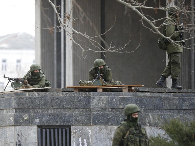 Armed men take up positions around the regional parliament building in the Crimean city of Simferopol March 1, 2014. U.S. President Barack Obama has warned Russia against any military intervention in Ukraine after the country's new leaders accused Moscow of deploying forces in the Crimea region. REUTERS/David Mdzinarishvili (UKRAINE - Tags: POLITICS MILITARY)