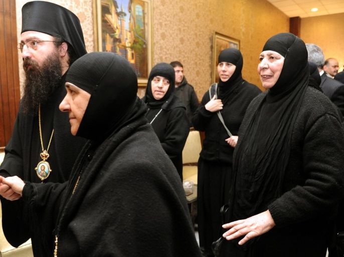 In this photo released by the Syrian official news agency SANA, a group of nuns who were freed after being held by rebels, greet church officials at the Syrian border town of Jdeidat Yabous, early Monday, March. 10, 2014. Rebels in Syria freed more than a dozen Greek Orthodox nuns on Monday, ending their four-month captivity in exchange for Syrian authorities releasing dozens of female prisoners. The release of the nuns and their helpers, 16 women in all, is a rare successful prisoner-exchange deal between Syrian government authorities and the rebels seeking to overthrow the rule of President Bashar Assad. (AP Photo/SANA)